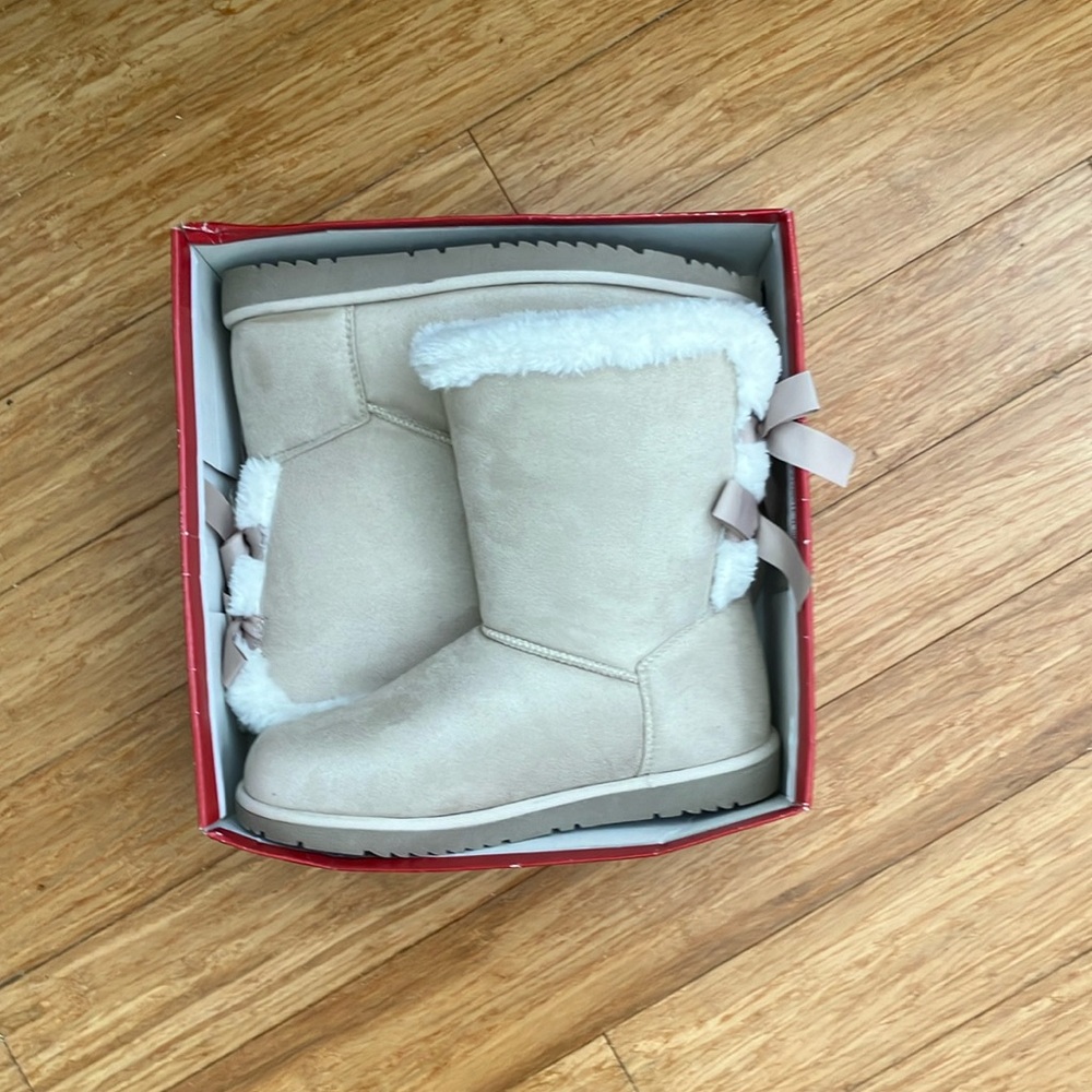 Boots size 10 in a soft white. With 2 bows on each shoe.